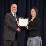 Doctor Potteiger posing for a photo with an award recipient in a black blazer and a grey patterened skirt